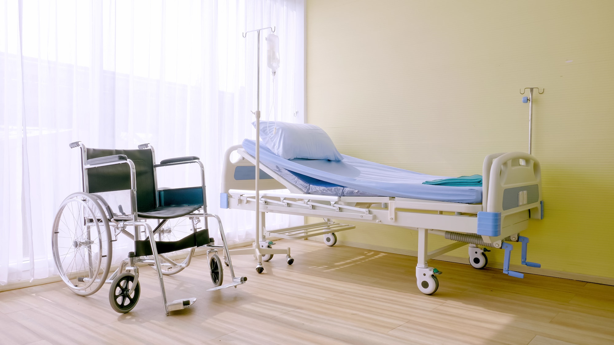 Hospital bed and wheelchair at hospital room.