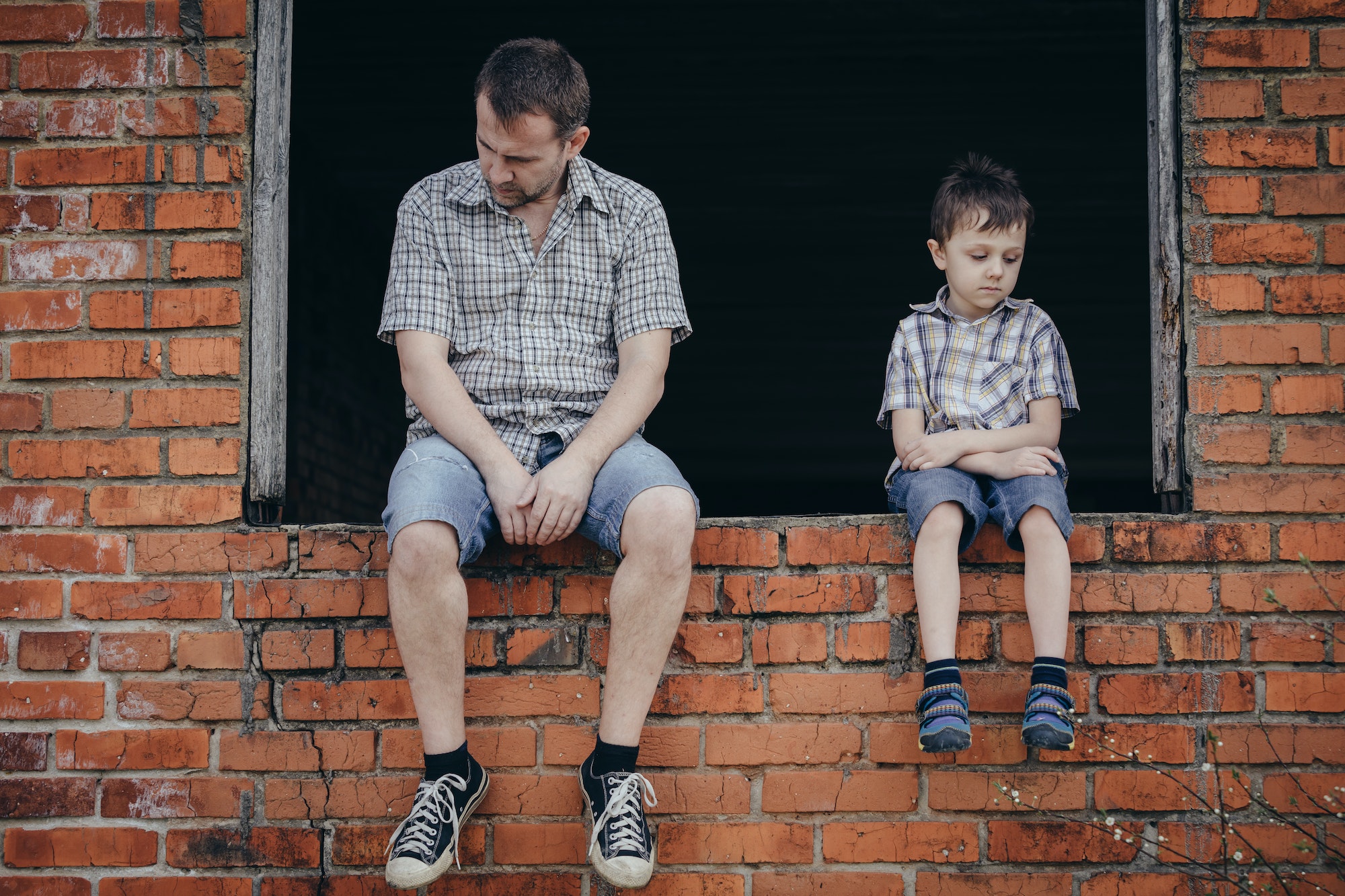 Portrait of sad little boy and father.